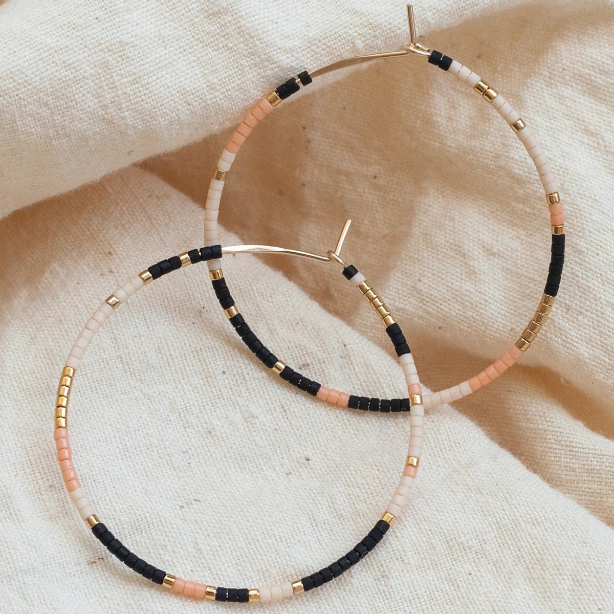 Beaded hoops earrings in a southwest palatte called Sienna, in pink, cream, matte black, and gold