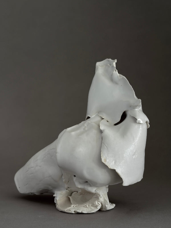 White porcelain ceramic sculpture of a bird created in a modern brutalist style, embracing the beauty in the imperfections