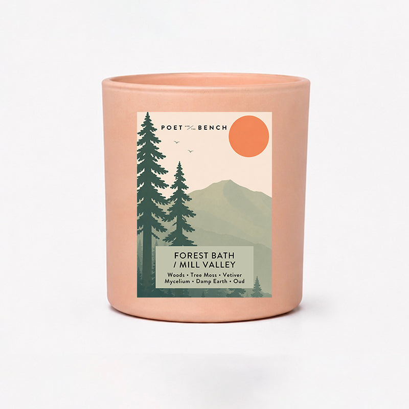 Candle in a blush colored vessel with a label depicting the forests in Mill Valley and on Mt Tamalpais