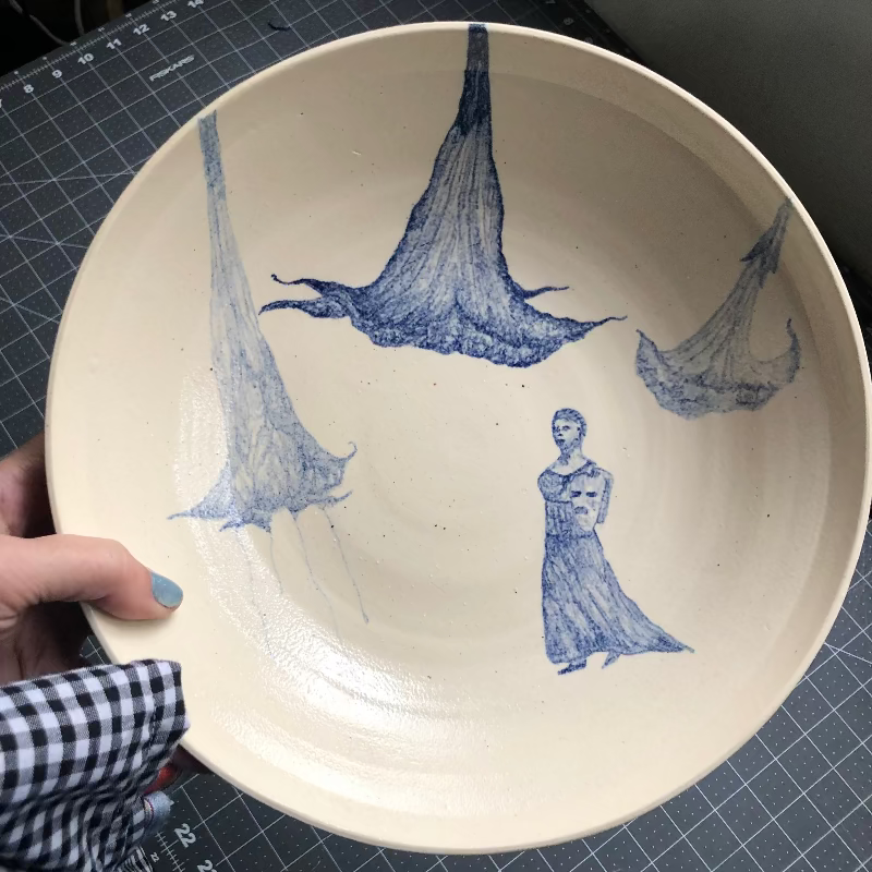 Large ceramic serving bowl with blue watercolor painting of trumpet flowers and a drama statue.