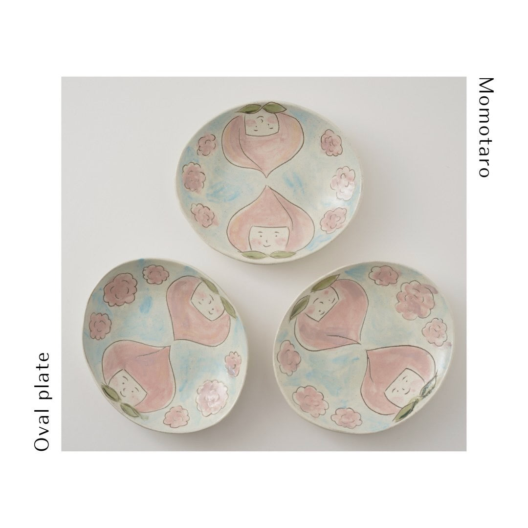 This small 6" oval plate features Momotaro, born from a peach and who conquered ogres.
Momotaro wears a peach headdress and goes cherry blossom viewing in this
personality-filled series from Kikuko's imagination. 