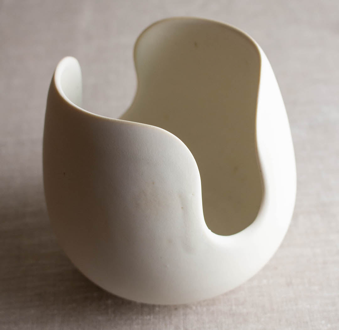 Rounded form with deep cut out rim. One of a kind white crystalline matte porcelain objects are mid-century Scandinavian inspired by Lisa Fleming.