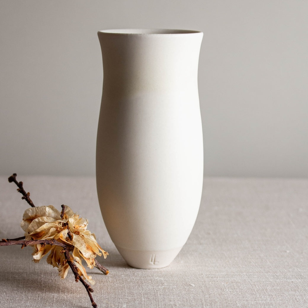 Vase form with a flared rim. One of a kind white crystalline matte porcelain objects are mid-century Scandinavian inspired by Lisa Fleming.