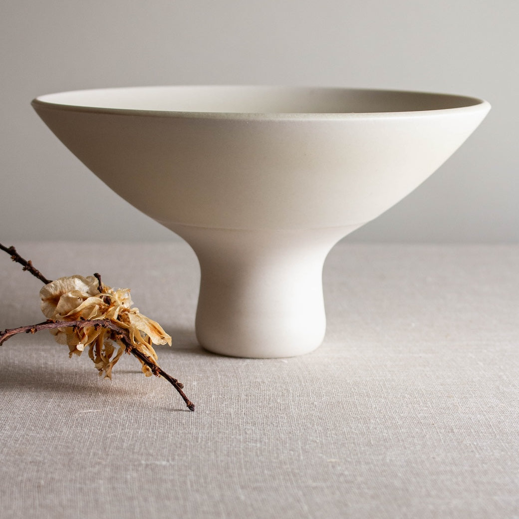 Pedastal vessel with rounded tall foot. One of a kind white crystalline matte porcelain objects are mid-century Scandinavian inspired by Lisa Fleming.