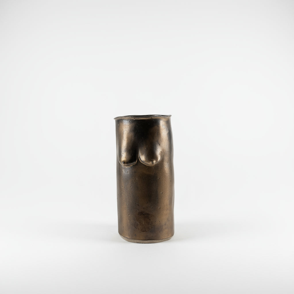 Bronze vase with breast forms on a plain background