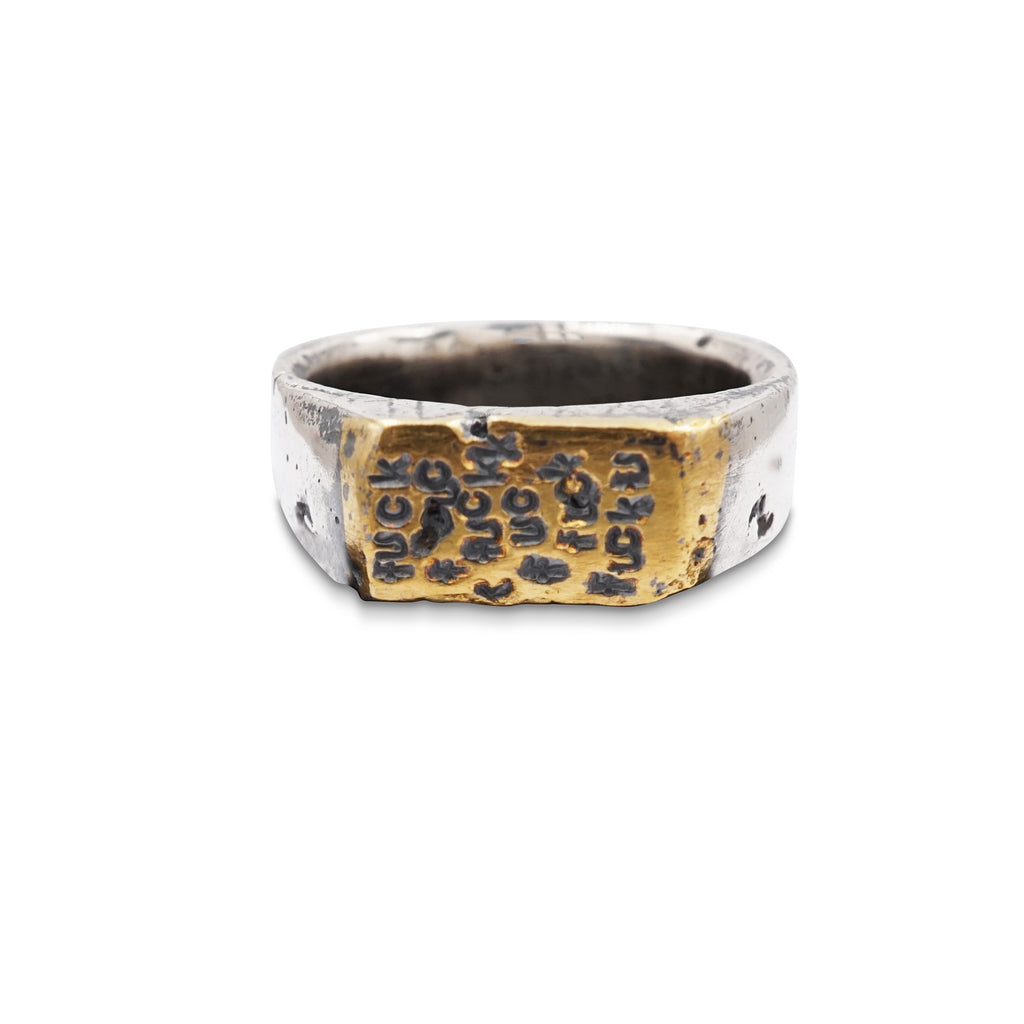 Sterling silver signet ring with 23K gold foil on the face of the ring is carved in wax and then sand cast in house and stamped with the f-word, multiple times