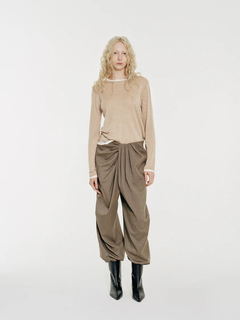 The Lyric sculptural trousers reinterpret traditional tailoring through fluid draping and precise construction. Crafted from fine wool suiting fabric