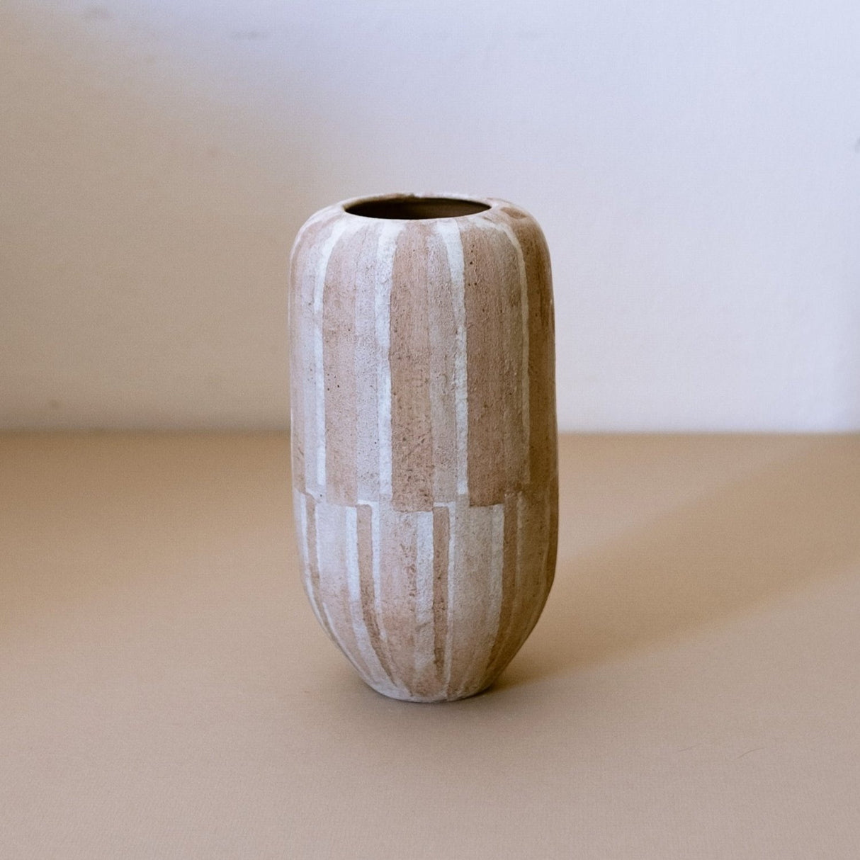 Tapered ceramic vase with painted wallpaper stripes.