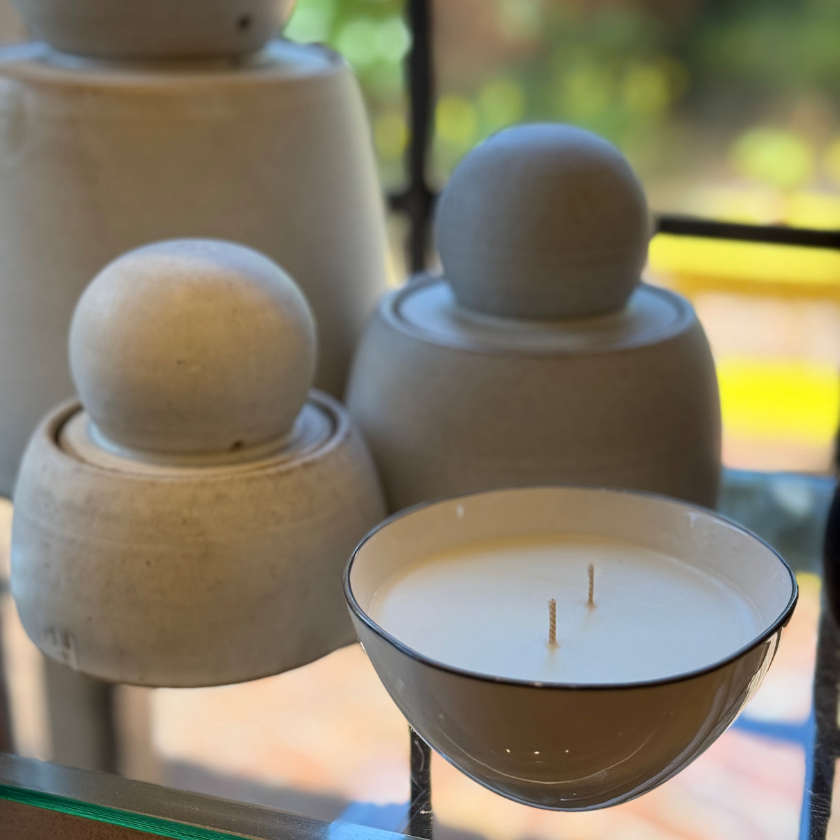 Seductive candle with non-toxic fragrance in vegetable wax in a reusable porcelain bowl. No 9 by Poet and the Bench. Shown with MH Ceramics Stash Jars