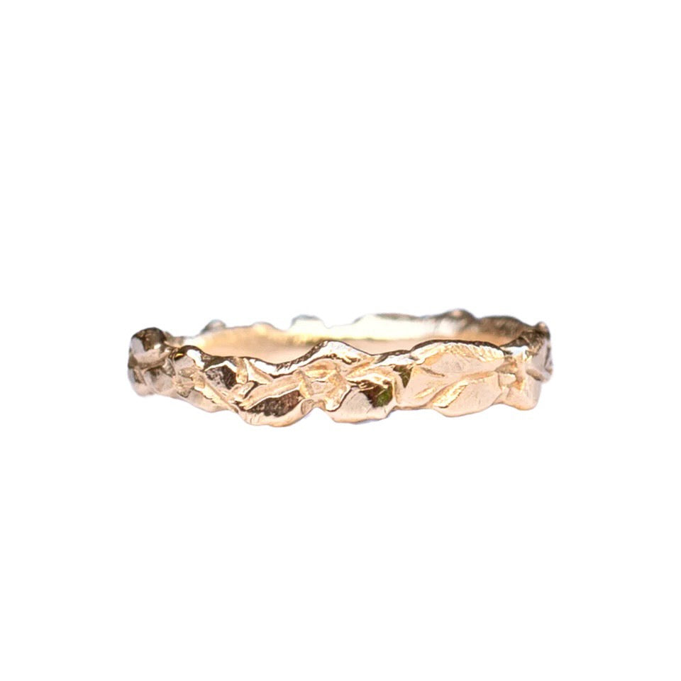 Sindri is a narrow stacking ring with carved flower detail.