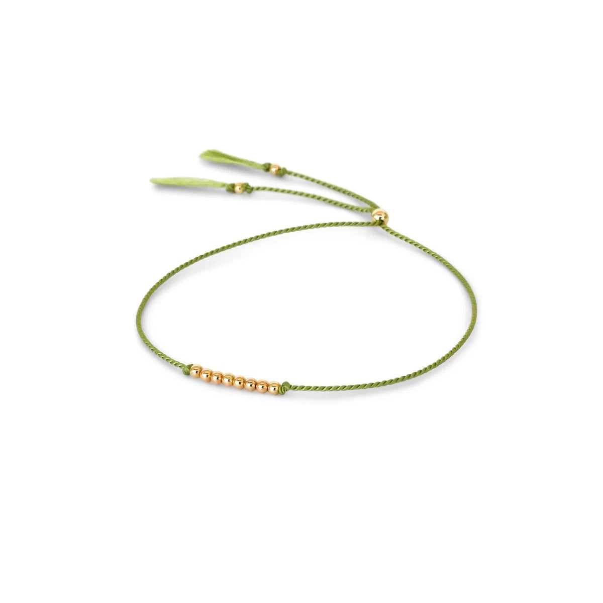 A delicate pear green cord bracelet featuring a central cluster of small 14k gold filled beads and adjustable pear green tassel ends, displayed on a clean white background.