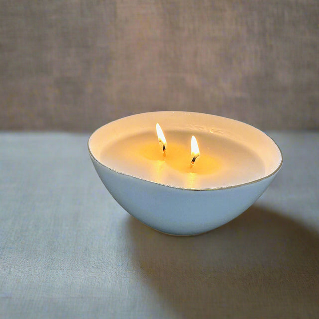 Our inhouse line of candles with sophisticated, compelling scents. Soy wax and clean fragrance. White candle in a white porcelain reusable bowl.