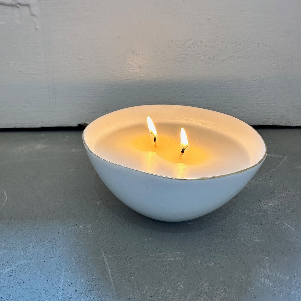 Our inhouse line of candles with sophisticated, compelling scents. Soy wax and clean fragrance. White candle in a white porcelain reusable bowl.