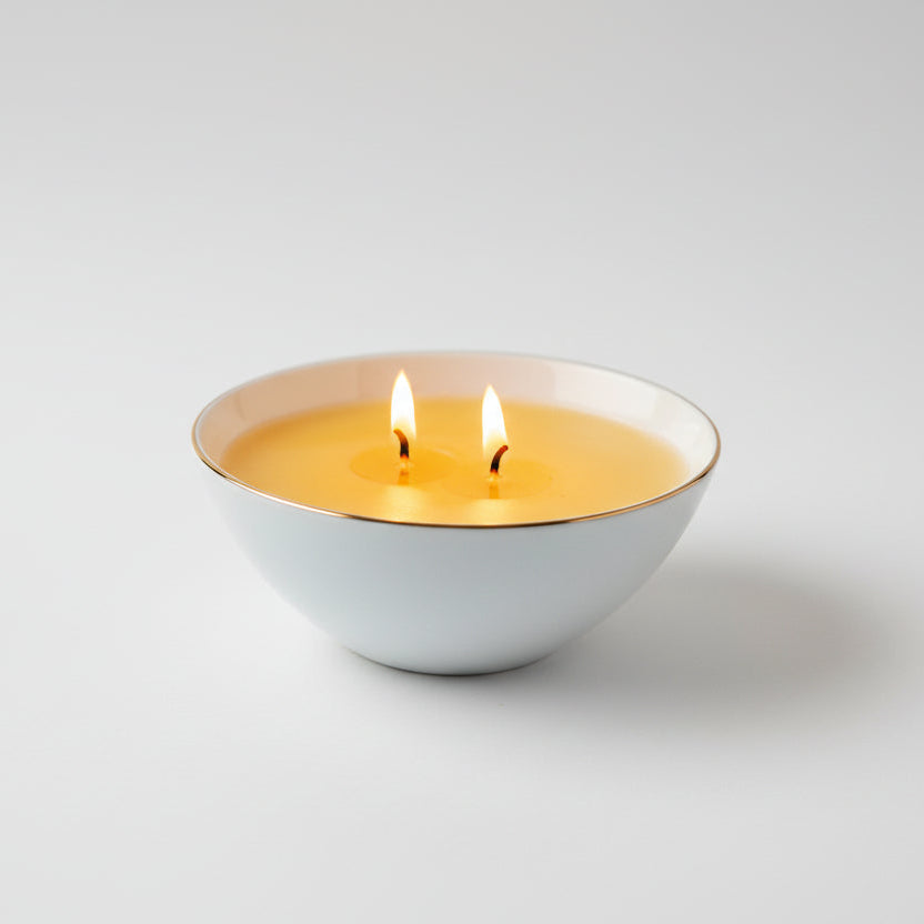White ceramic candle bowl with gold rim and with two wicks. Part of the Atmosphere collection to shift your mood, memory and space