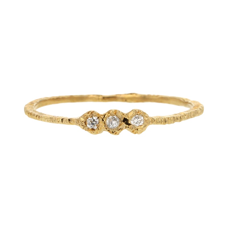 Add texture to your ring stack with this elegant yellow gold super skinny etched band set with three white diamonds by Danielle Welmond