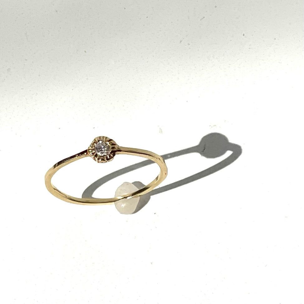 A delicate and super cool single stone stacking ring to add to your every day. We love the textured diamond setting (round bezel) of the white diamond contrasted with the smooth band.