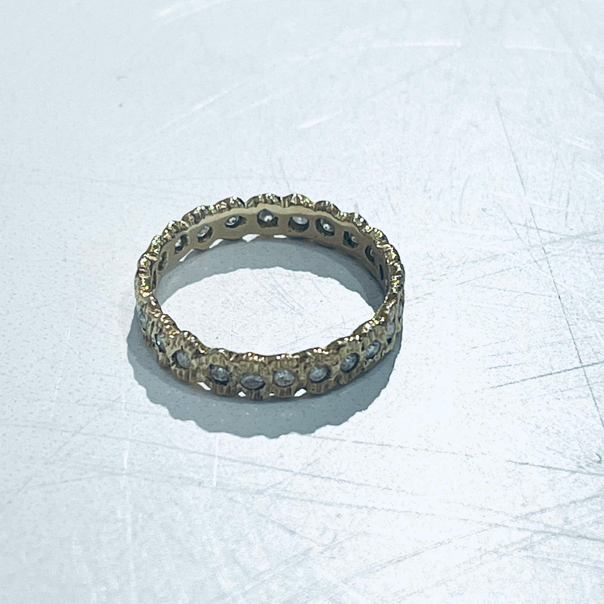 Add texture to your ring stack or wedding ring with this stunning textured yellow gold looped eternity diamond band.
