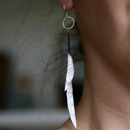 Esther Metals Feathery Earrings will be your go-to earrings with their glistening silver handcrafted feathery wings. Shown on model.