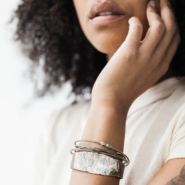 Jacqueline unisex cuff by Franny E of fine silver and bronze on model.