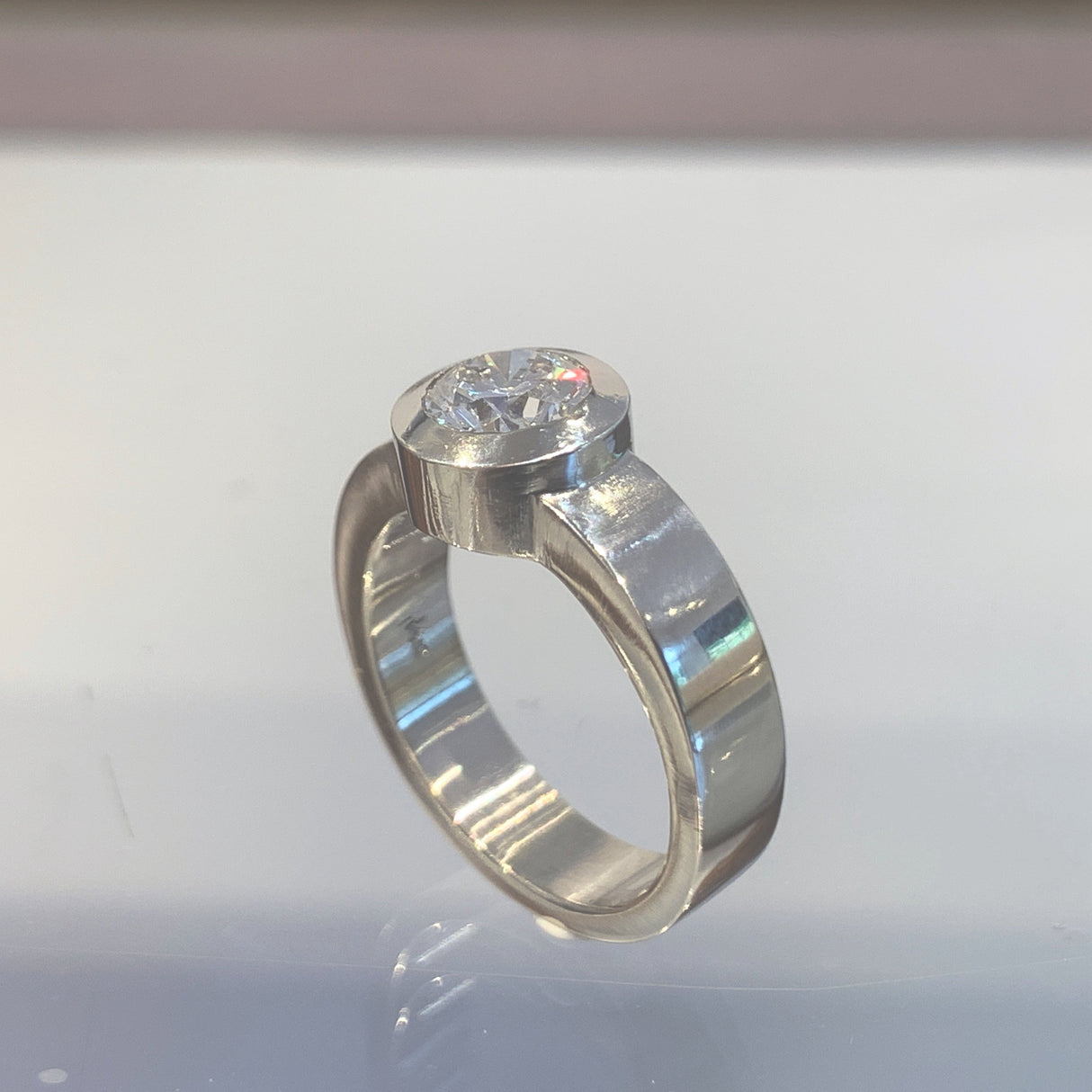 The white gold engagement ring (mounting) was hand carved in wax and cast in white gold with Jeffrey’s signature flush-set design.