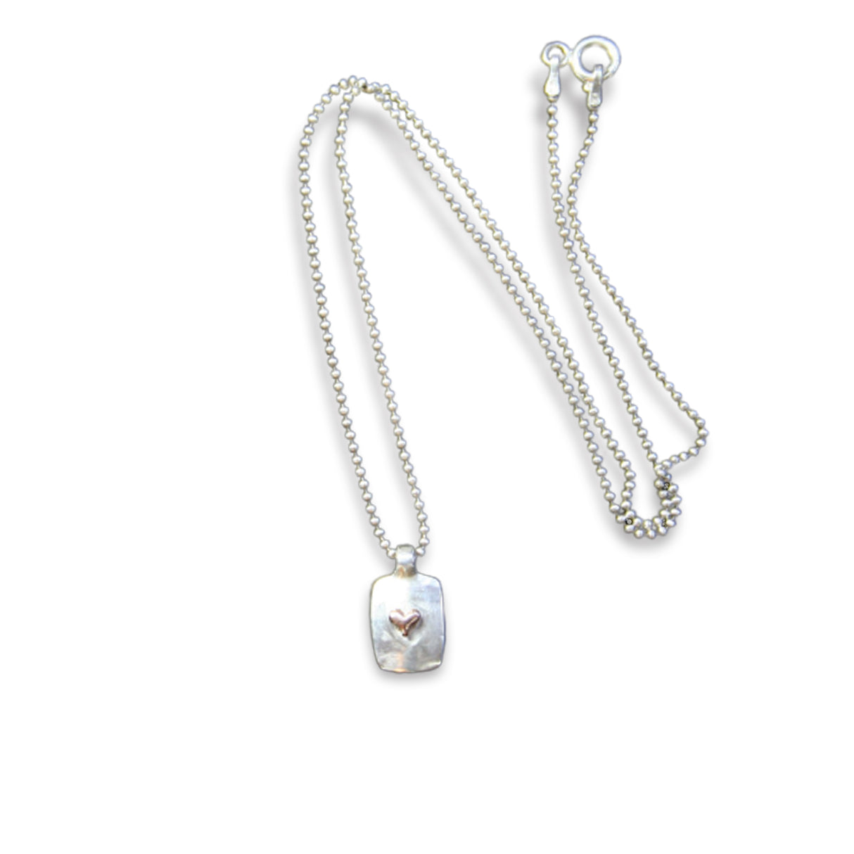 Jeffrey reimagined the classic dog tag into a modern canvas, both refined and a bit edgy. He loves mixing metals and embellished this sterling silver dog tag with a contrasting 14K rose gold tiny heart charm.