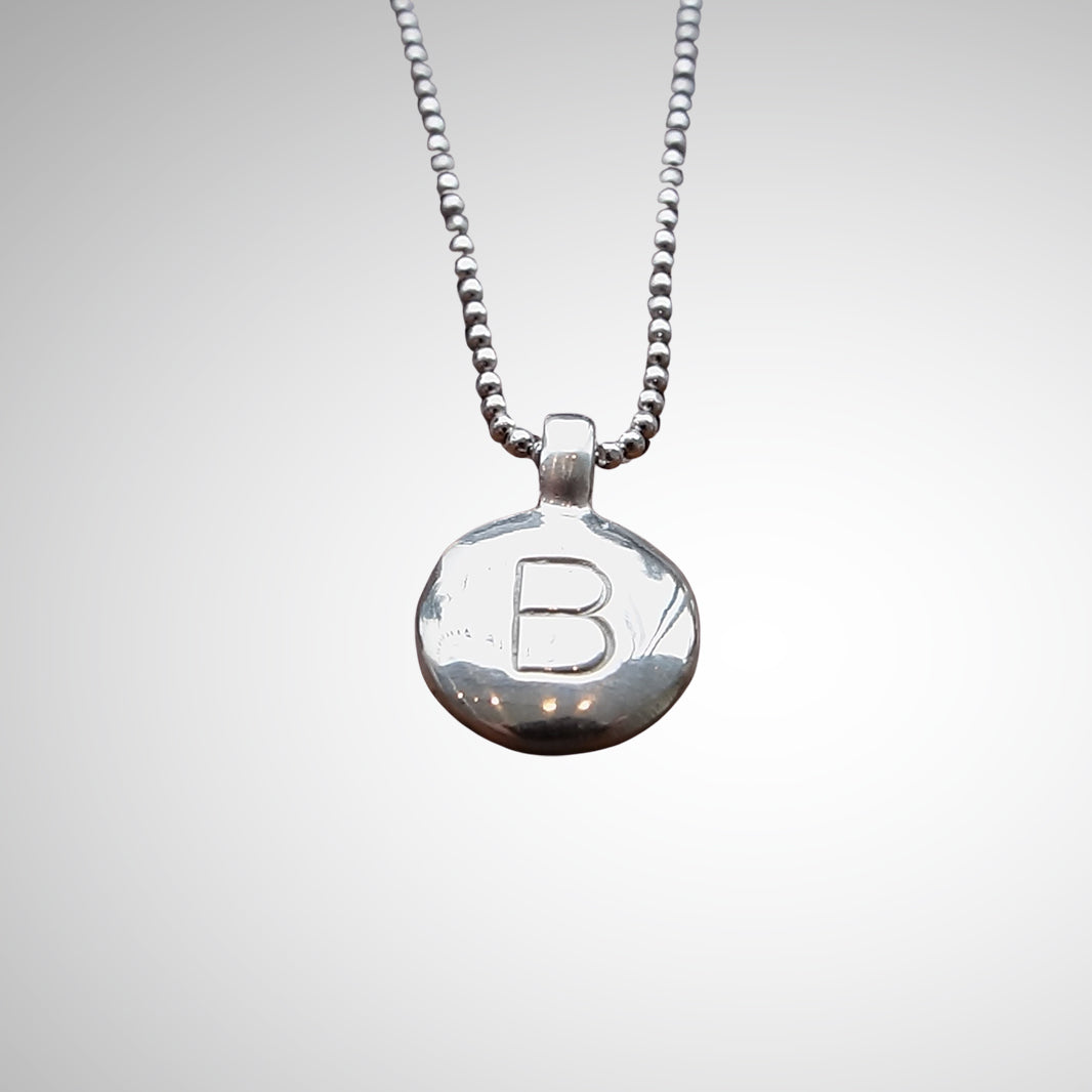 Jeffrey created a medallion canvas that has simple, clean lines with a strongly tactile feel. We love the sterling silver medallion with stamped initials.