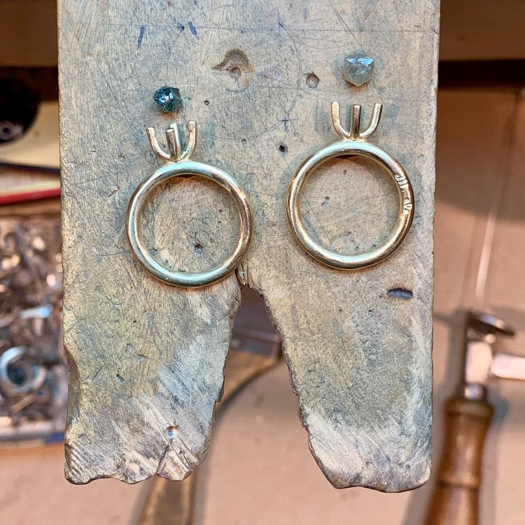 Rough diamond ring settings and rough diamonds in the process of production.