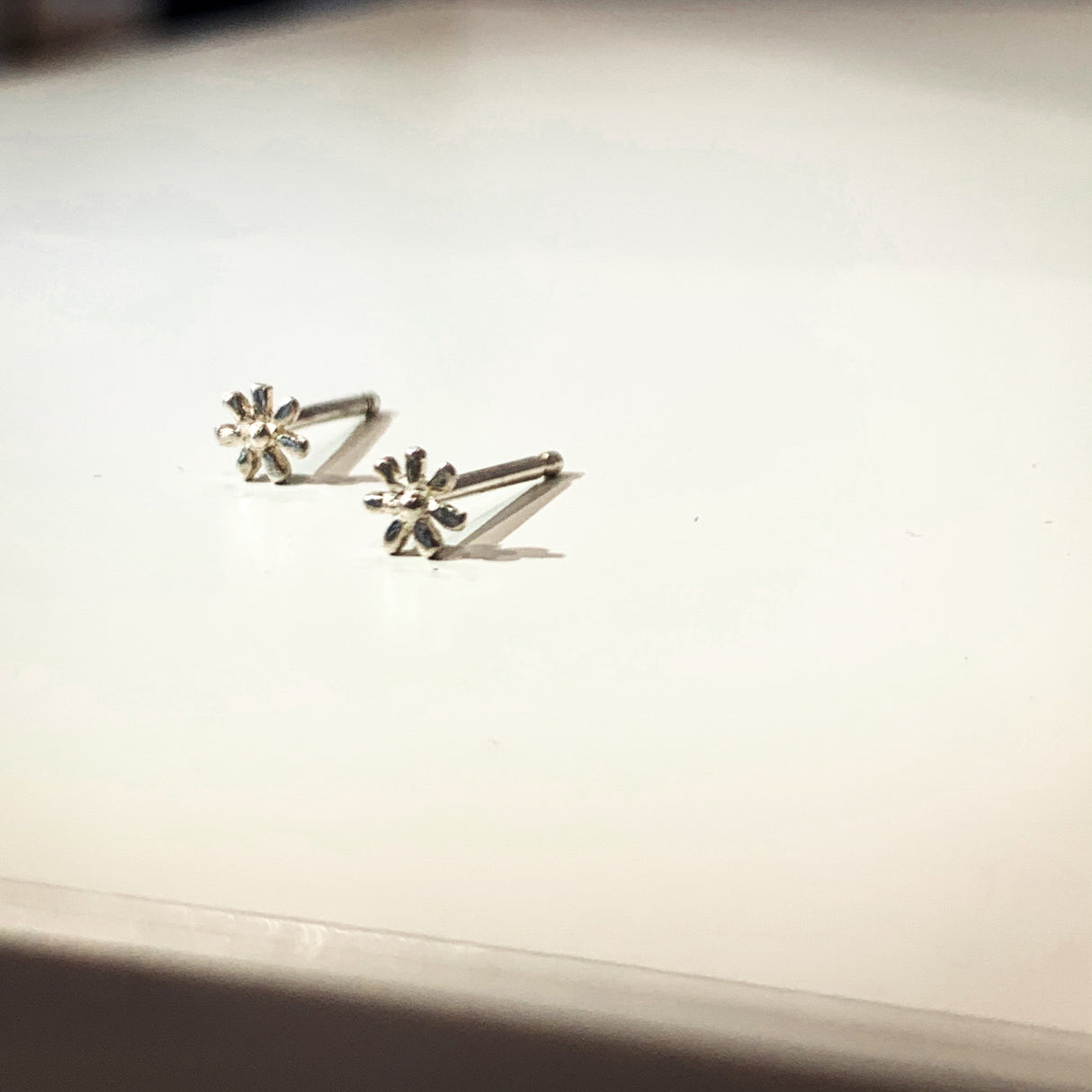 A delicate flower but mighty in spirit. These are his most tiny, carved by hand in wax before being cast in precious metals. Perfect for layering as multiples. Sterling silver shown on side.