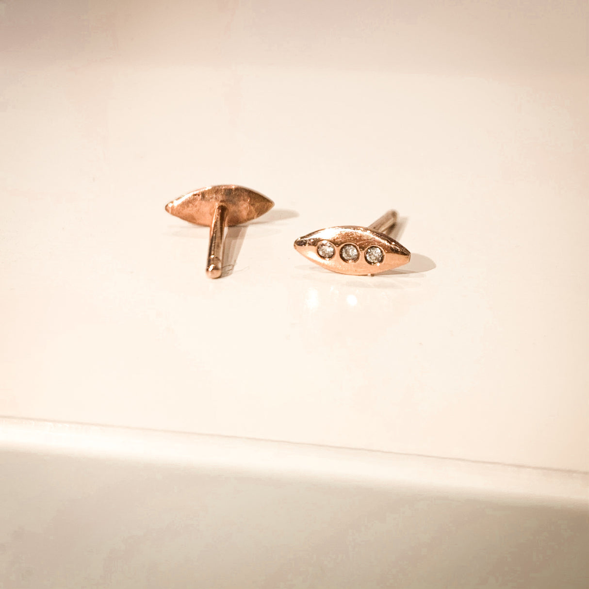 A tiny shield for protection, adorned in diamonds. Tiny earrings carved by hand in wax before being cast in precious metals. Rose gold and white diamond