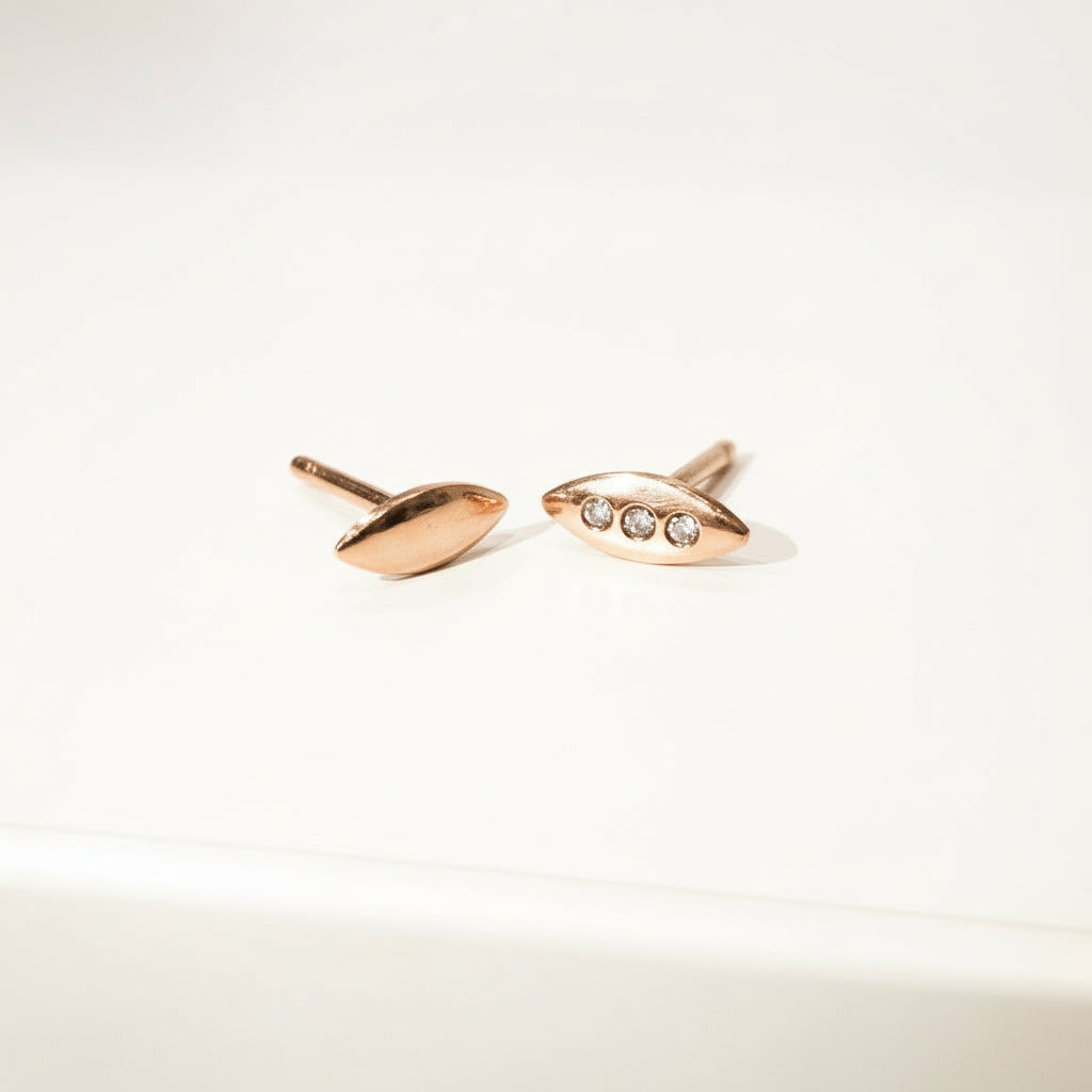 A tiny shield for protection, adorned in diamonds. Tiny earrings carved by hand in wax before being cast in precious metals. Rose gold and white diamond