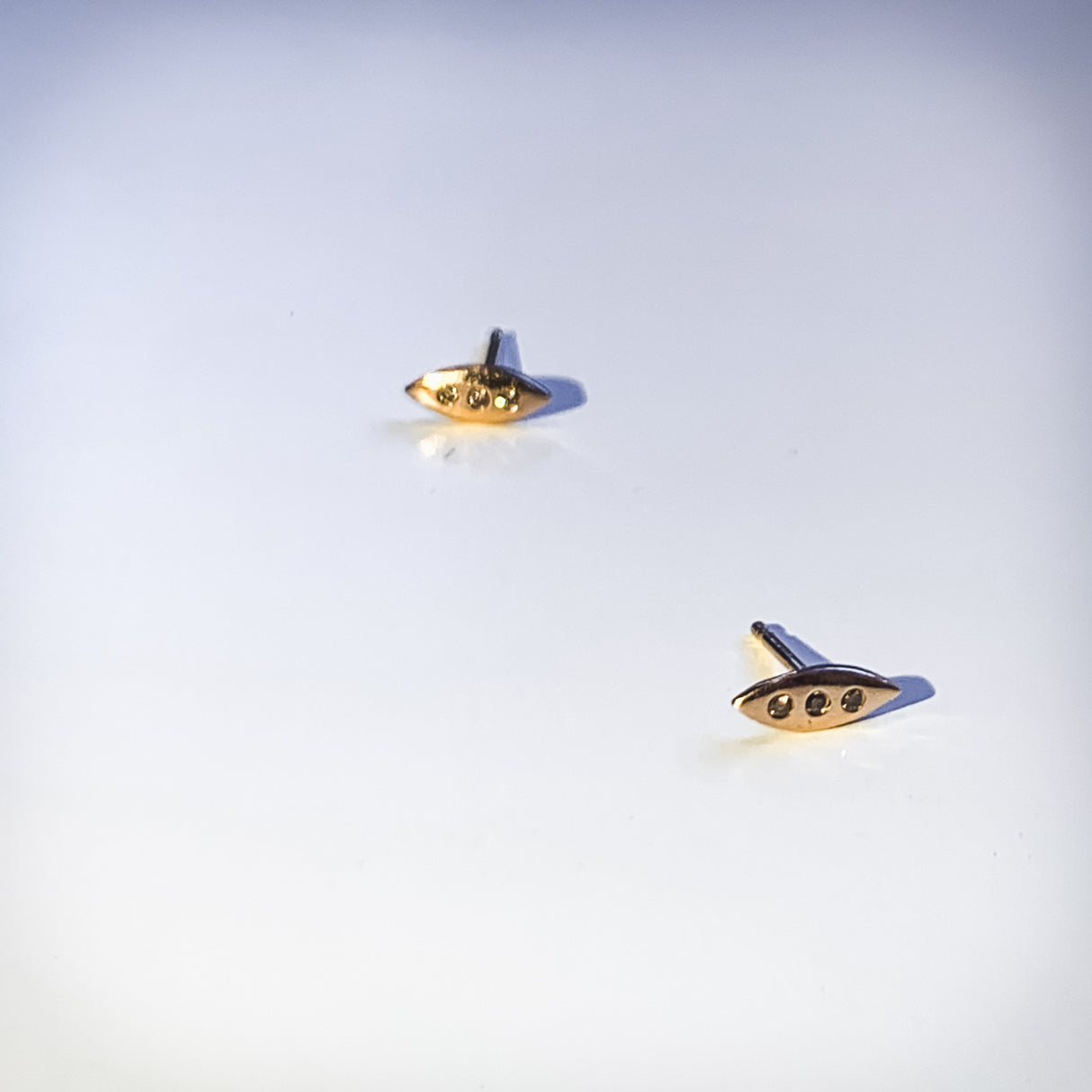 A tiny shield for protection, adorned in diamonds. Tiny earrings carved by hand in wax before being cast in precious metals. Rose gold and diamonds