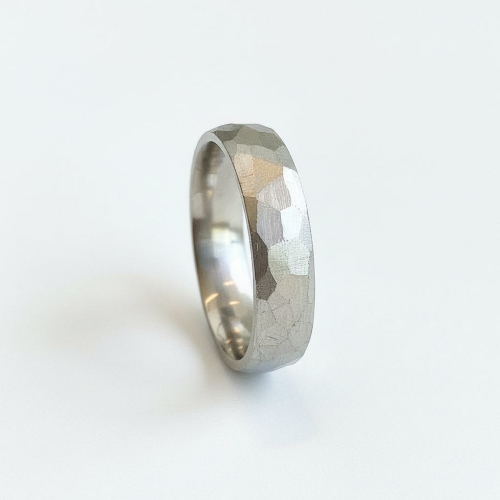Jeffrey's hand carved wedding band in platinum has facets that captures the light. A unisex wide ring it is a modern option on its own or stacked with an engagement ring for stunning textural contrast. Platinum wedding band