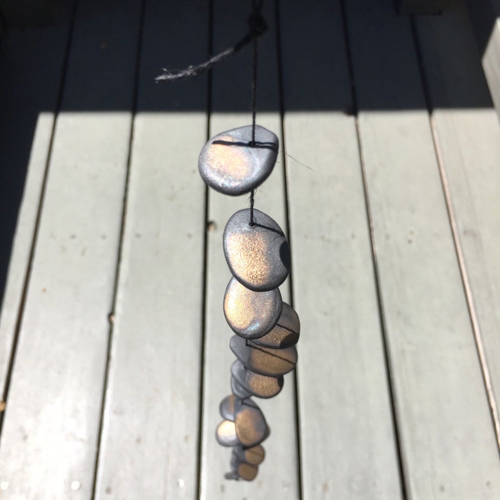 The Droplets is a hand built ceramic wall hanging with references to water, pebbles and other natural materials. The freeform shapes have a visceral quality, inspired by observations of landscape, the natural world, textiles, and metallic elements.