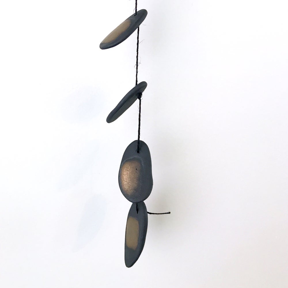 The Droplets is a hand built ceramic wall hanging with references to water, pebbles and other natural materials. The freeform shapes have a visceral quality, inspired by observations of landscape, the natural world, textiles, and metallic elements.