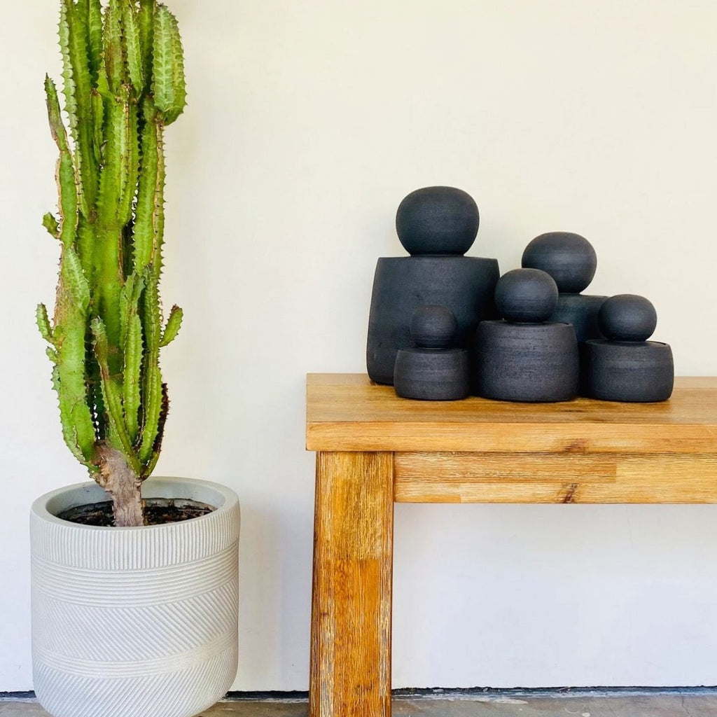 A most stylish ceramic canister with a gotta-touch-me chubby orb lid is your new fave to store everyday things. Shown in a group of various sizes.