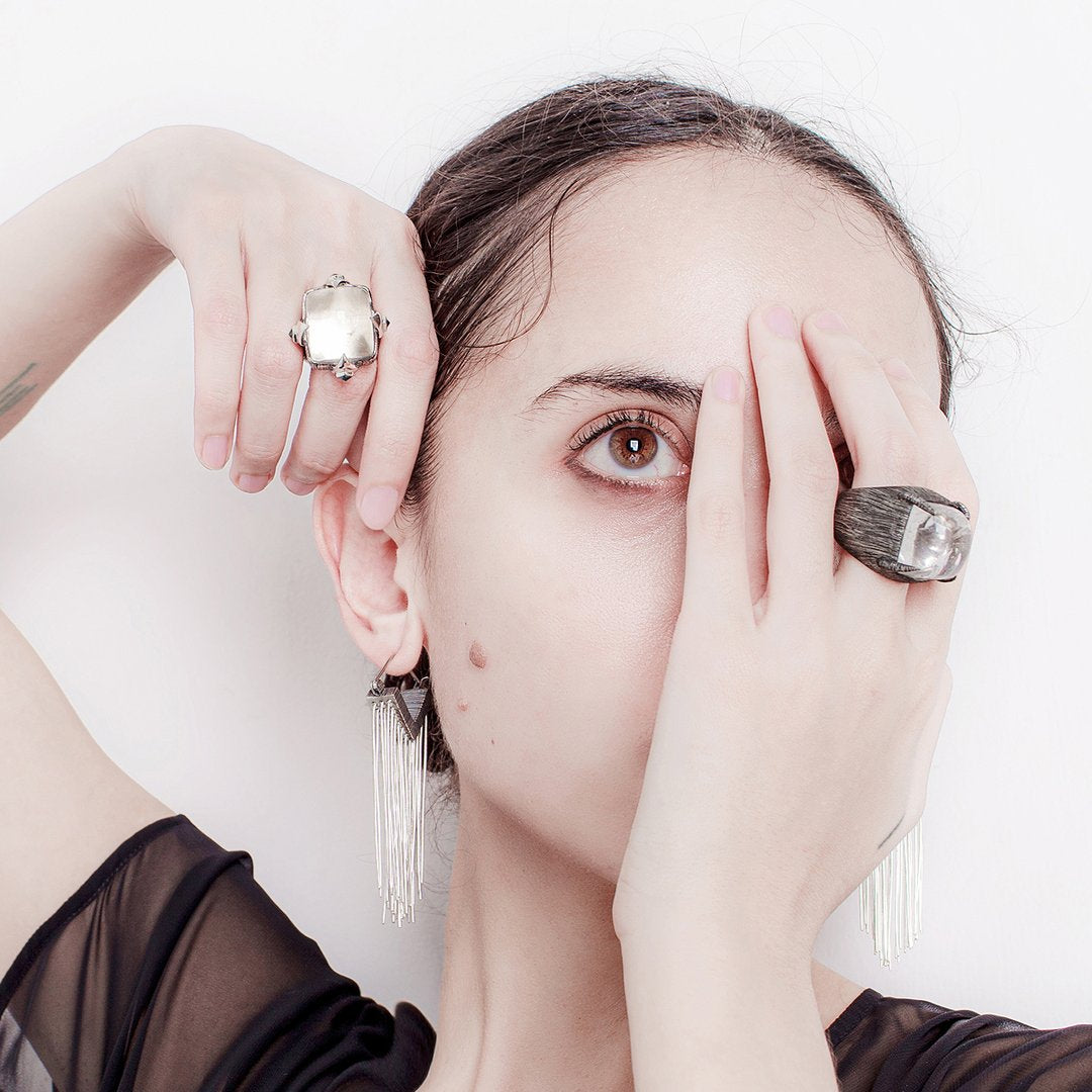 Always stay grounded. These Mariella Pilato earrings feature a cascade of silver wires resting in the air as if the aerial roots of a plant. On model.