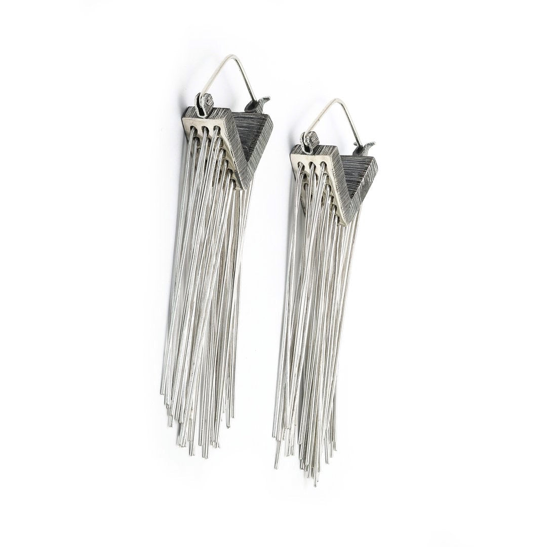 Always stay grounded. These Mariella Pilato earrings feature a cascade of silver wires resting in the air as if the aerial roots of a plant. Front view.