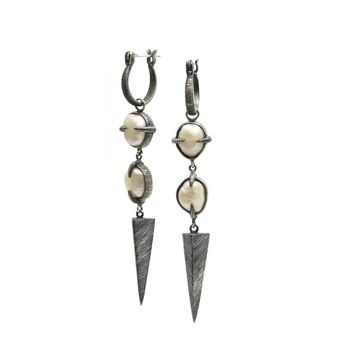 A pair of Baroque pearls clasped within textured and oxidized silver prongs that create a flow to which the eye is drawn to the end point of each earring.