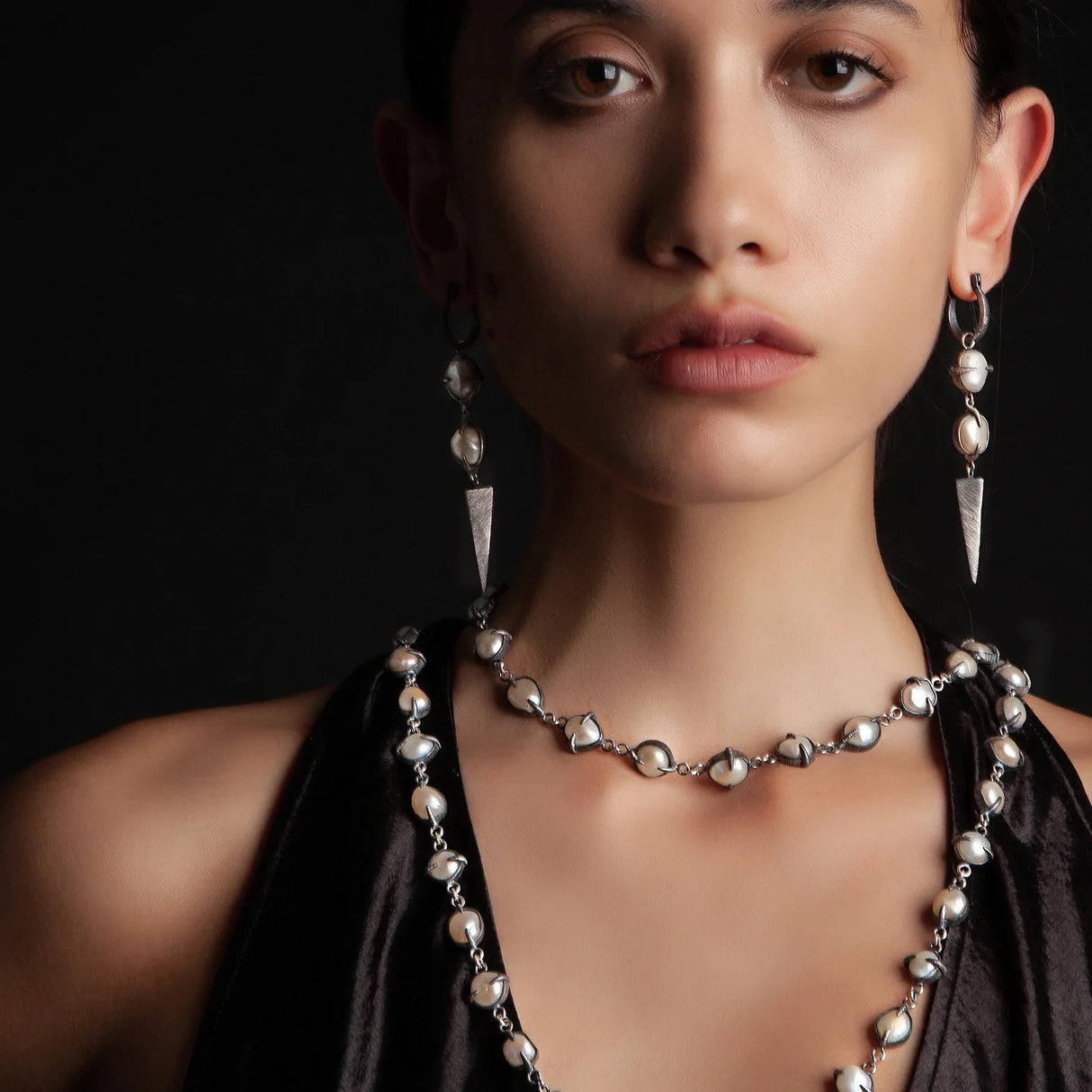 A chain of pearls ensconced in oxidized silver claws to surround your neck.
