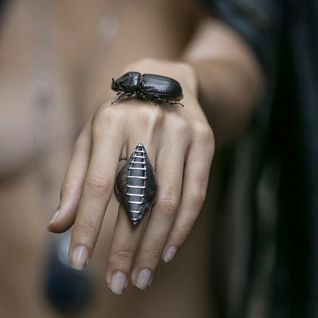 When you like a bold big ring... This dramatic elongated pod of polished bands of silver wire are constructed over a heavily etched silver container which opens slightly, revealing an oxidized interior.