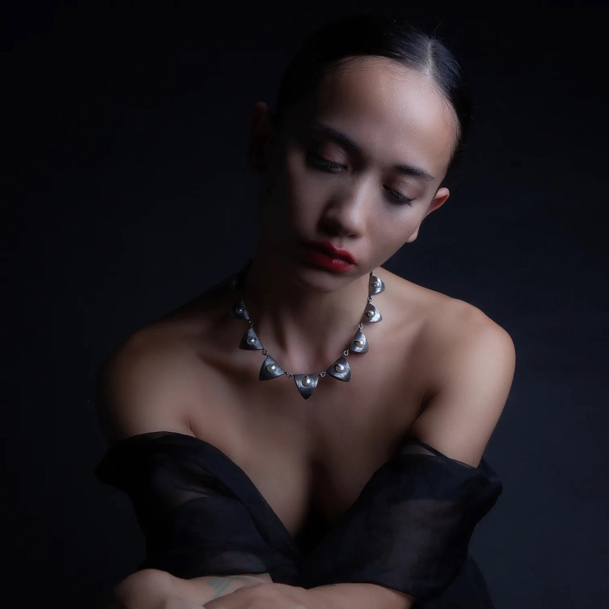 A chain of pearls ensconced in silver triangles descends from largest to smallest in a cascade of pearls and petals. Mariella Pilato designed this crazy cool choker necklace with brilliant detail. 