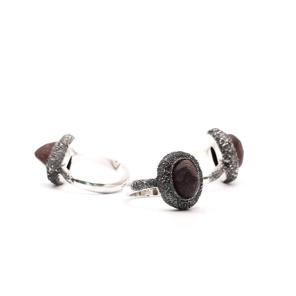 The rough faces of the garnets were found to be intriguing combined with the effect realized by powdering silver and then soldering and oxidizing the it onto the ring itself. 