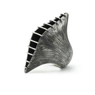 When you like a bold big ring... This dramatic elongated pod of polished bands of silver wire are constructed over a heavily etched silver container which opens slightly, revealing an oxidized interior. Angle view.