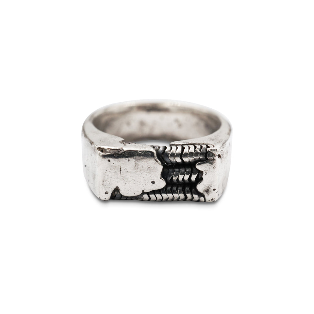 A signet ring made from hand poured molten silver that is sand cast in a mould with round chain links for added texture and dimension. Designer Anna of Metal Atelier intended to invoke the spirit of a child building a DIY robot! 