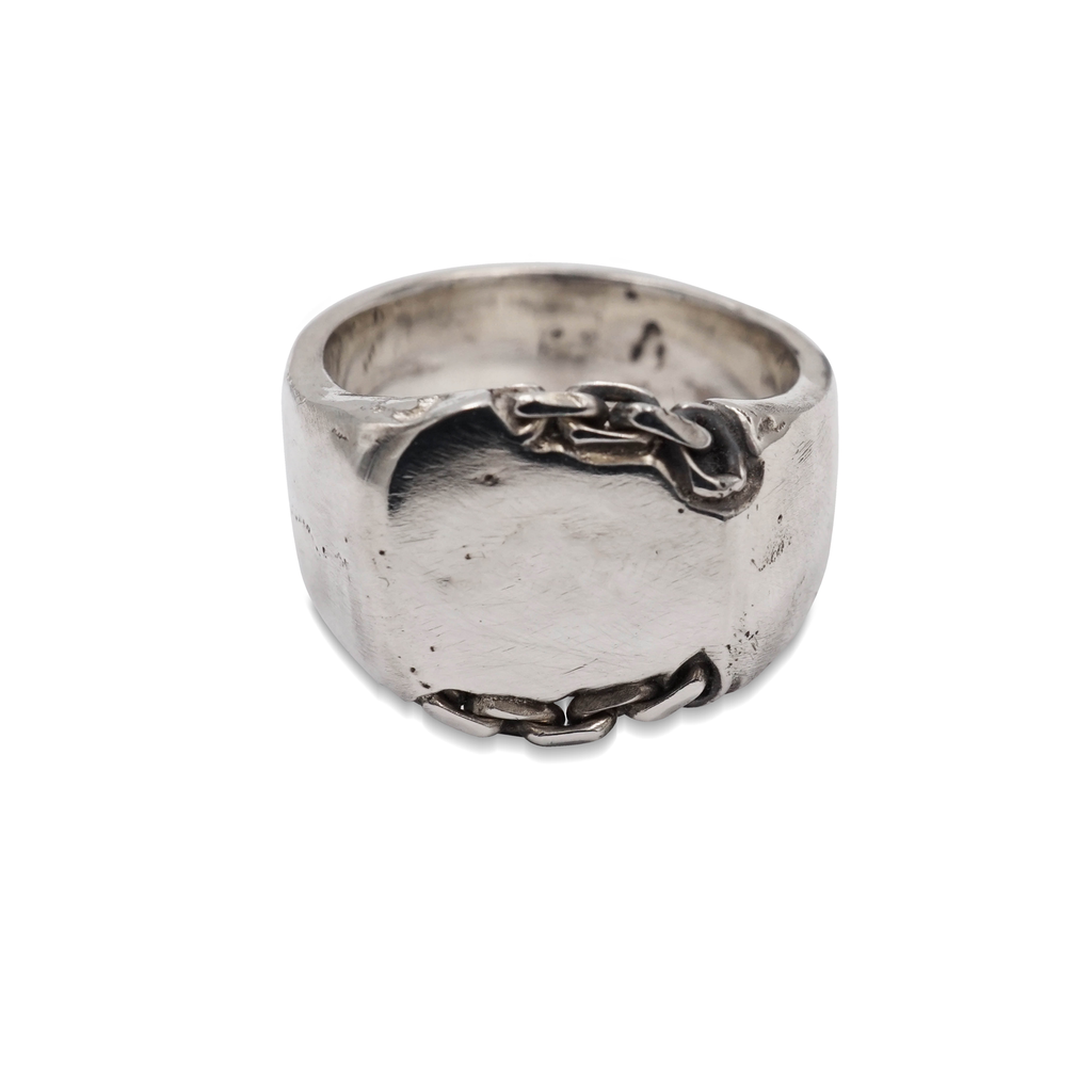 A signet ring made from hand poured molten silver that is sand cast in a mould with chain links for added texture and dimension
