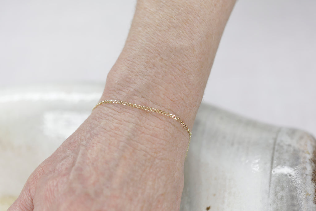 Permanent Jewelry Figaro Chain Link Bracelet shown on Bonnie's hand. Get Linked at Poet and/the Bench in Mill Valley. Together Permanent Jewelry for a Special Link to Yourself and Others at Poet and the Bench.