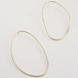 Asymmetrical oval olive-shaped brass earring hoops boast a sophisticated yet modern aesthetic.