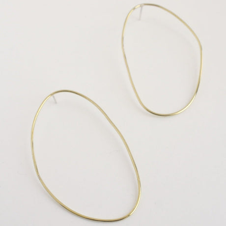 Asymmetrical oval olive-shaped brass earring hoops boast a sophisticated yet modern aesthetic.