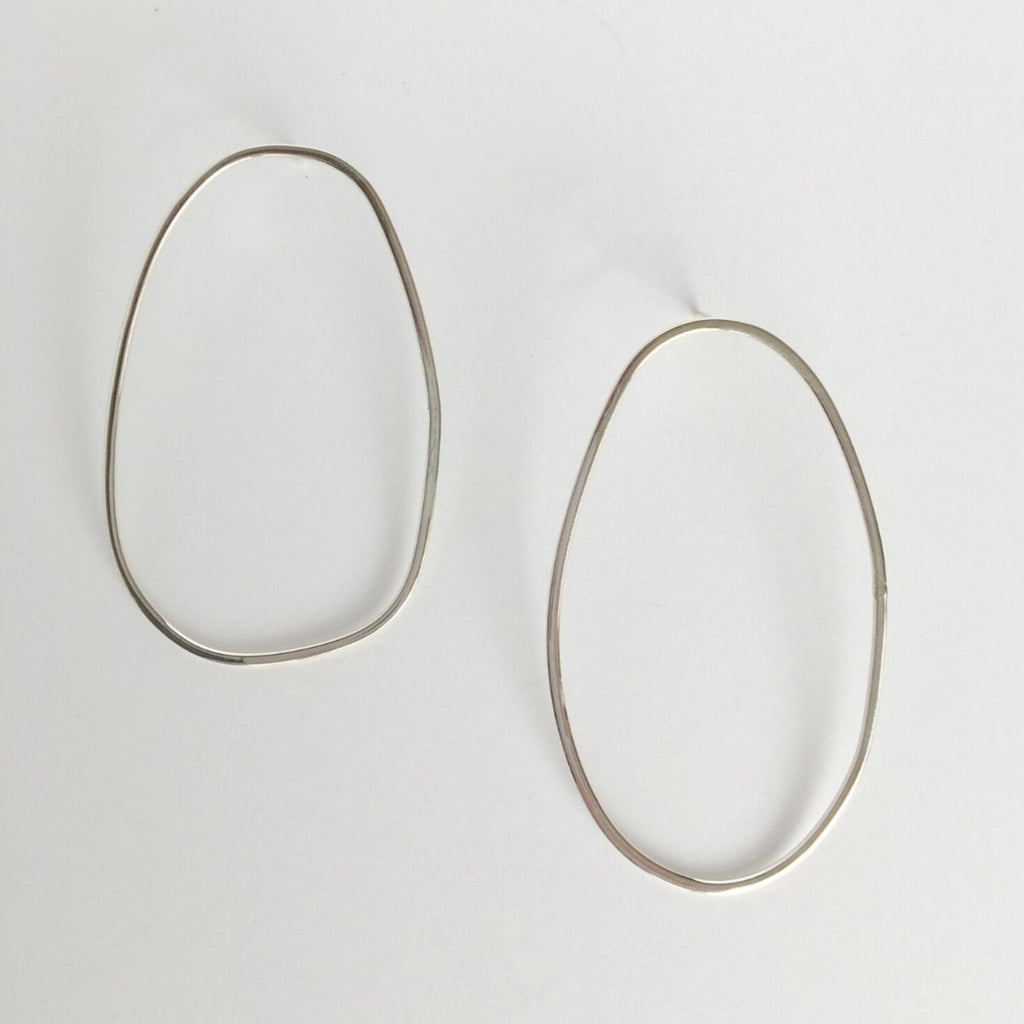 Asymmetrical oval olive-shaped sterling silver earring hoops boast a sophisticated yet modern aesthetic. 