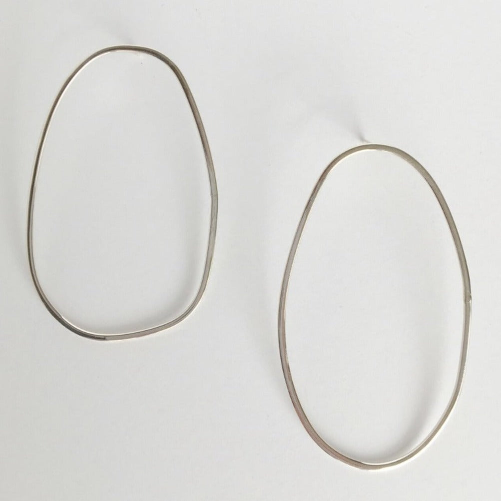 Asymmetrical oval olive-shaped sterling silver earring hoops boast a sophisticated yet modern aesthetic. 